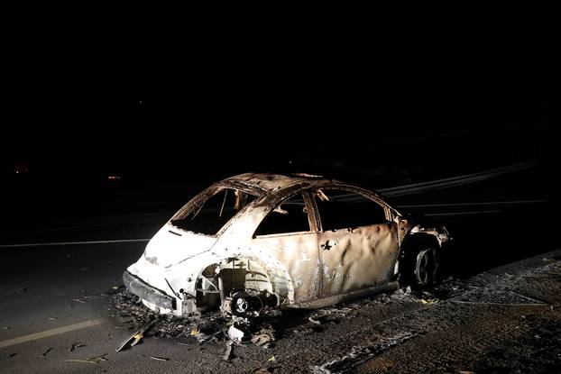 An abandoned vehicle is seen on a road during the Camp Fire in Paradise