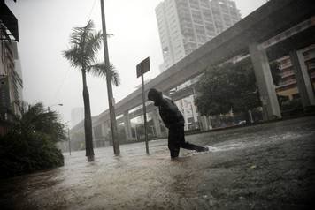 A local resident walks across a flooded street in downtown Miami as Hurricane Irma arrives at south Florida