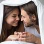 Young smiling couple in bed having fun covered with blanket