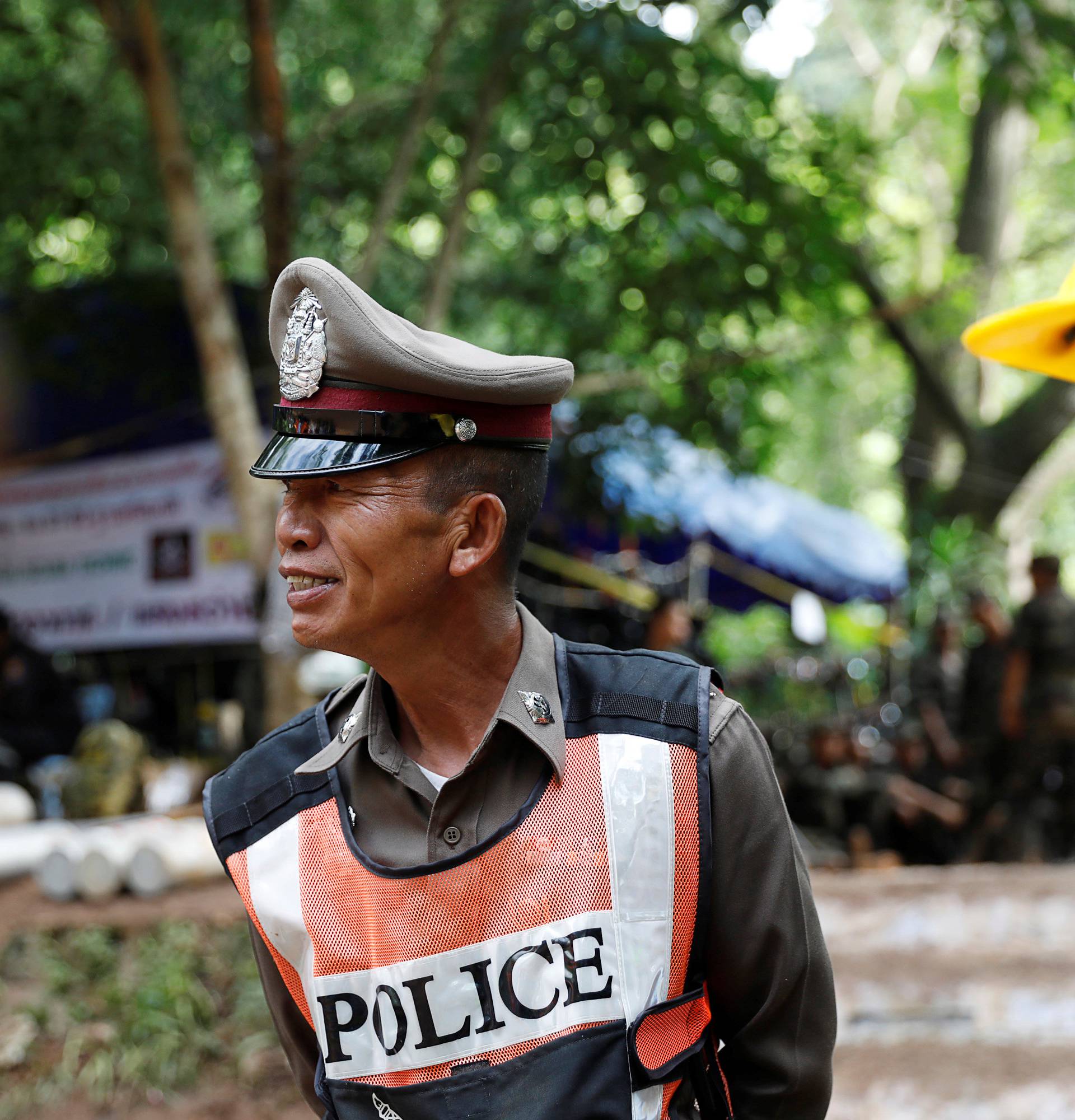 Police and rescue workers pass their time near the Tham Luang cave complex, as members of an under-16 soccer team and their coach have been found alive according to local media in the northern province of Chiang Rai