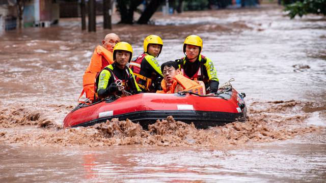Rescue workers evacuate stranded residents on a flooded street in Chongqing
