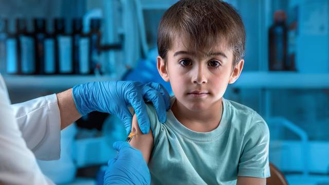 doctor injecting vaccine preventive to little boy in the hospita