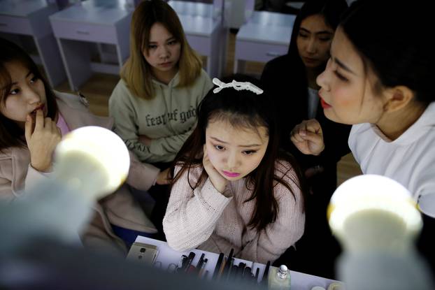 Girls attend make-up training session at live streaming talent agency Three Minute TV, in Beijing