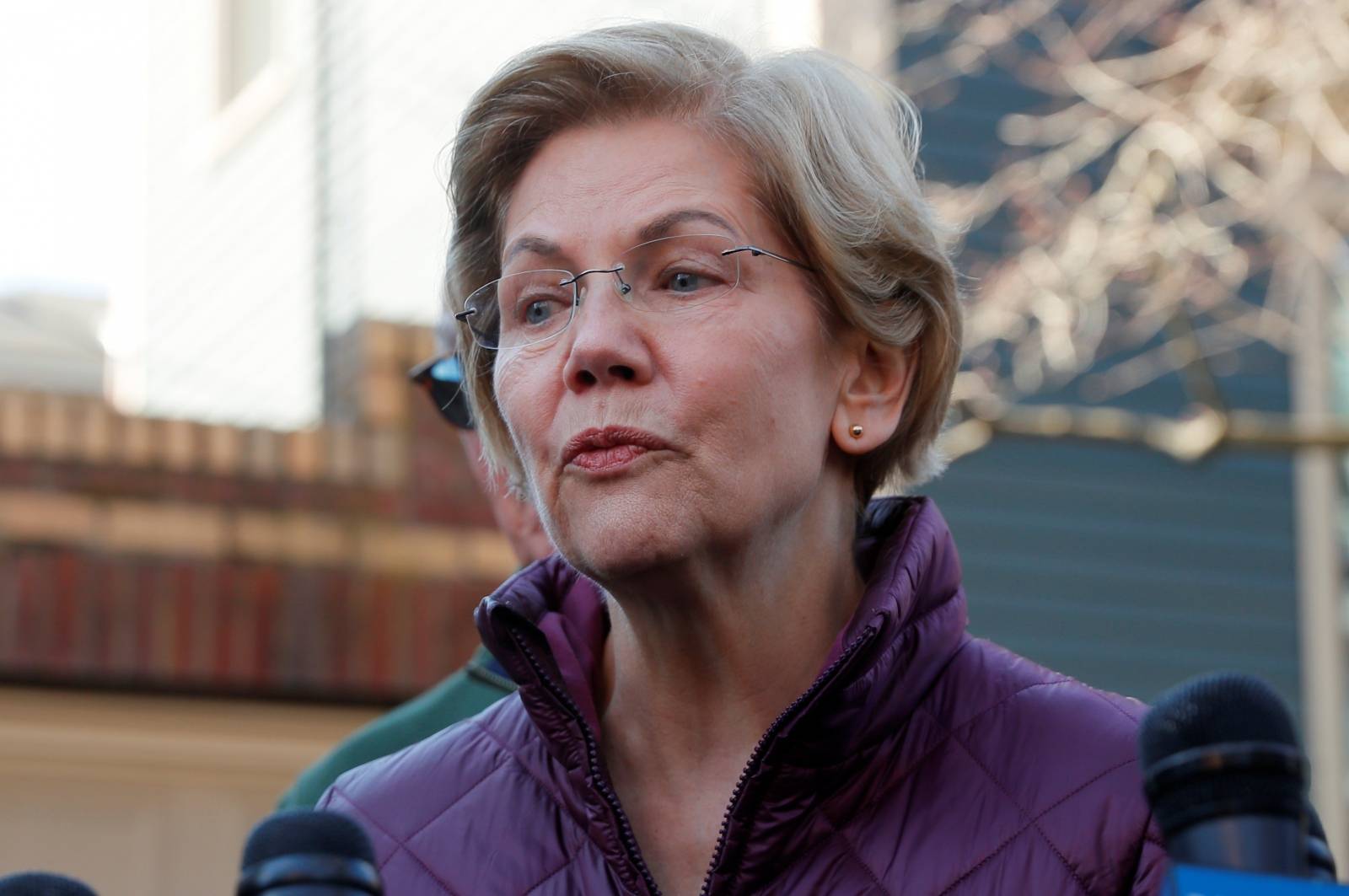 FILE PHOTO: Senator Elizabeth Warren talks to reporters after telling her staff she is withdrawing from 2020 U.S. presidential race outside her home in Cambridge, Massachusetts