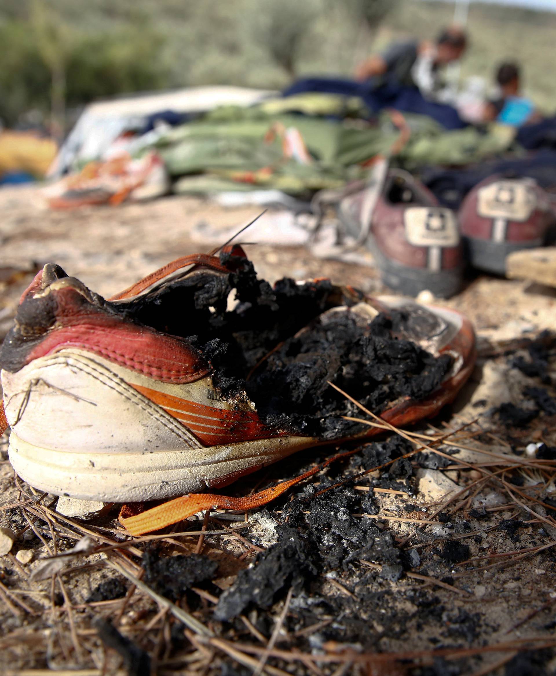 A burned shoe is seen on the ground, after a fire that ripped through tents and destroyed containers during violence among residents, on the island of Lesbos