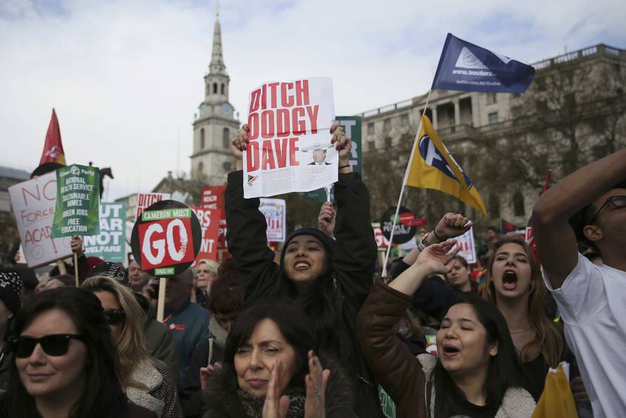 Demonstrators hold placards during an anti-austerity protest in London