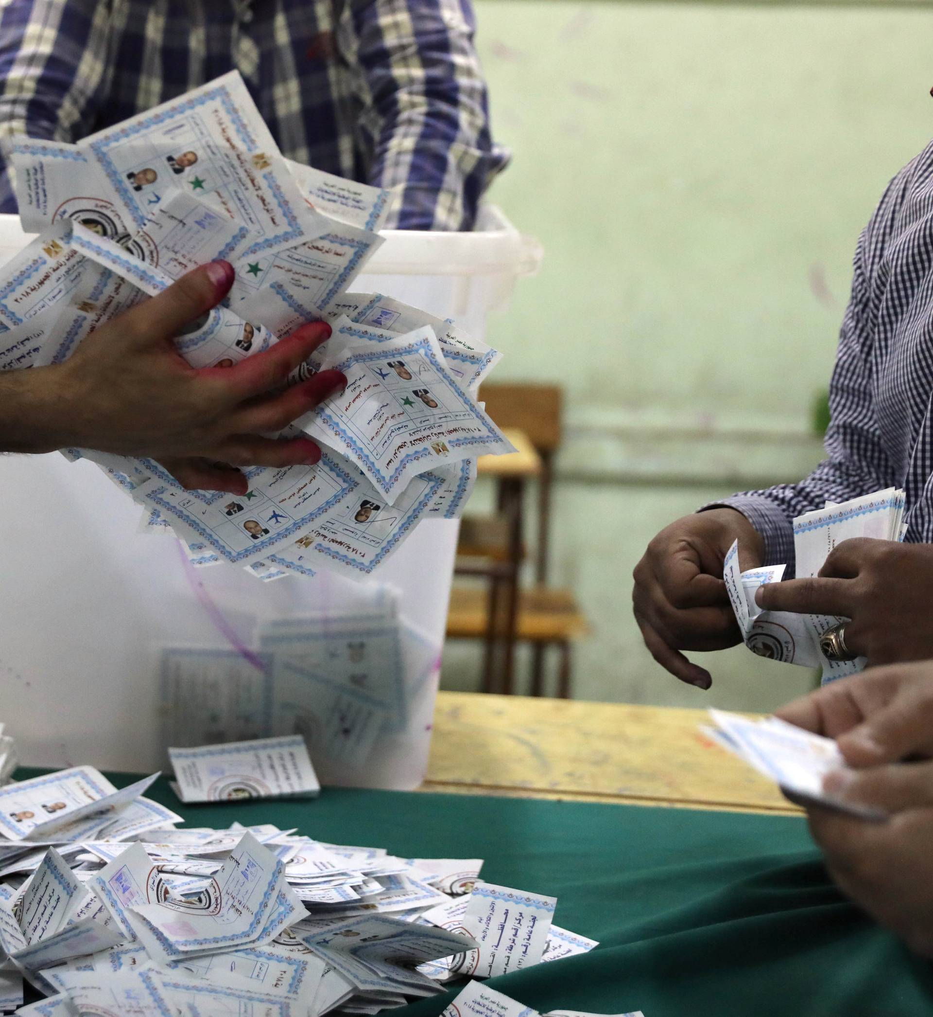 Electoral workers sort ballots to count votes after polls closed during the presidential election in Cairo