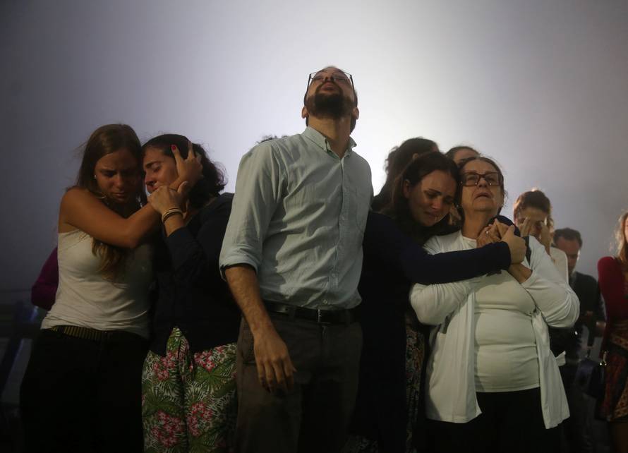 Relatives of Brazilian journalist Guilherme Marques mourn during a mass in Rio de Janeiro