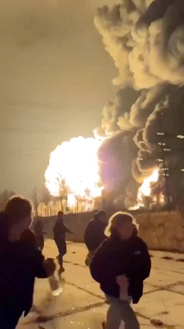 People run as smoke rises from an explosion during what the governor of Russia's Ryazan region southeast of Moscow describes as an air attack, in Ryazan