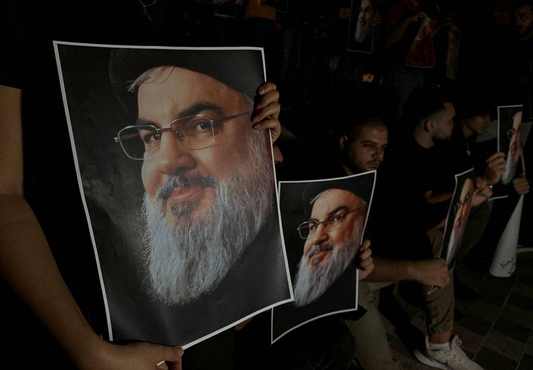 Supporters of Lebanon's Hezbollah leader Sayyed Hassan Nasrallah carry his pictures as they gather in Sidon