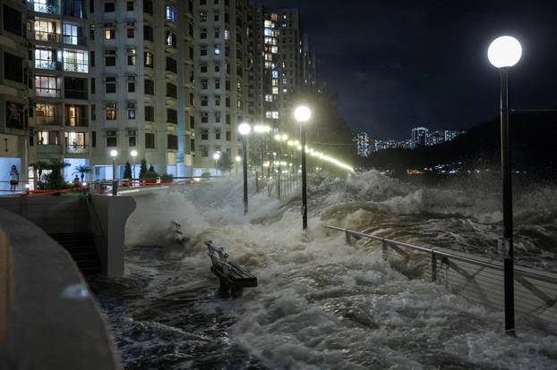 Waves from Super Typhoon Ragasa crash onto chairs by the shore in Hong Kong