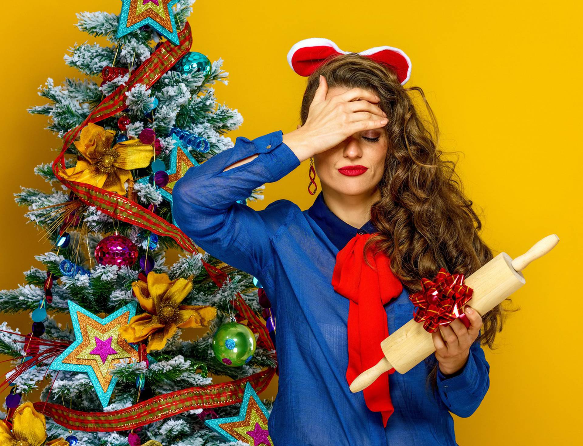 woman near Christmas tree holding unwanted present