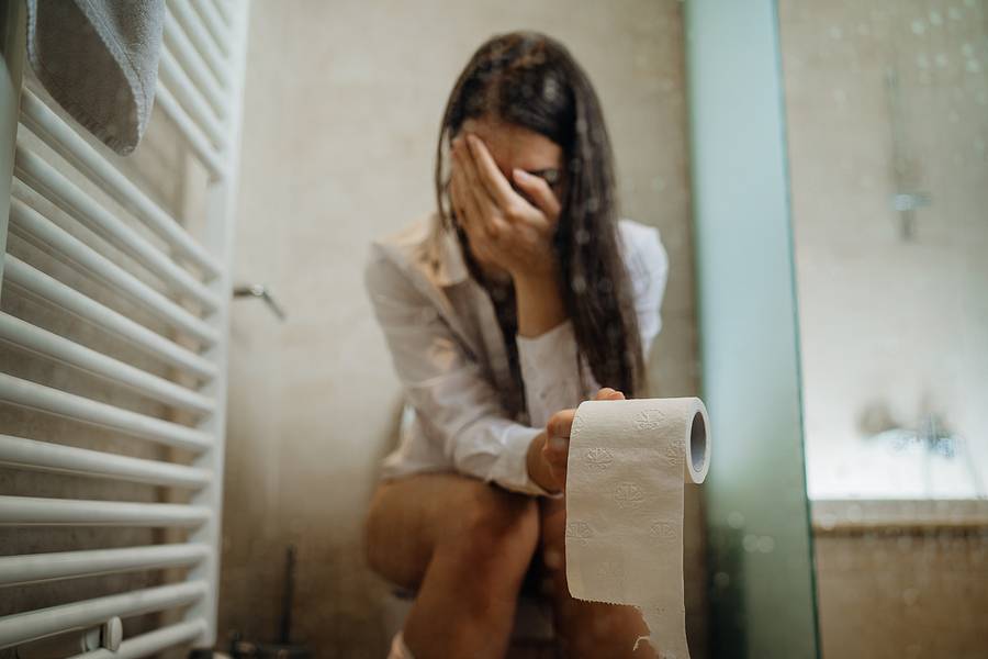 Sad Woman On The Toilet With Toilet Paper,suffering From Abdomin