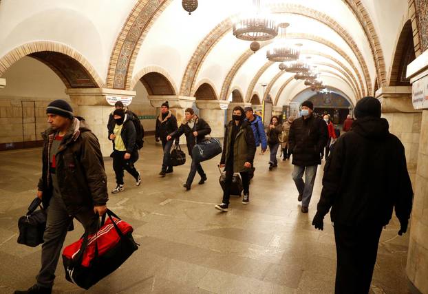 People walk in a subway station, after Russian President Vladimir Putin authorized a military operation in eastern Ukraine, in Kyiv