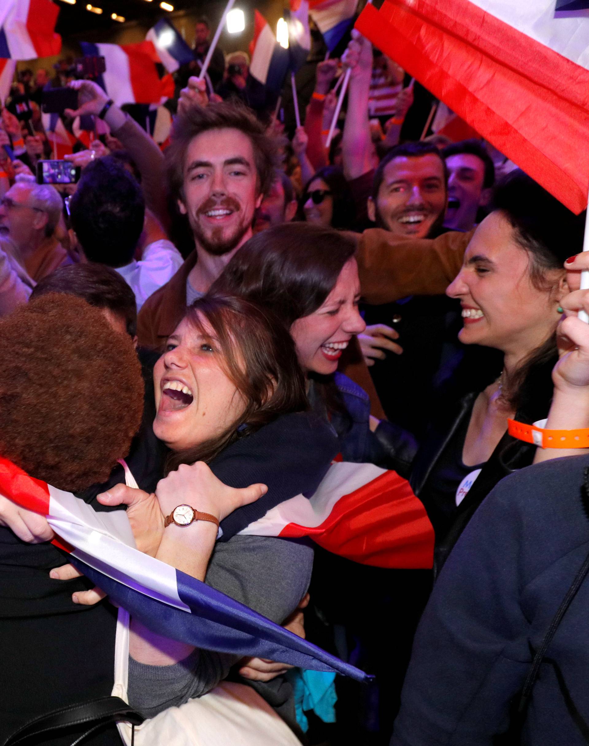 Supporters of Emmanuel Macron, head of the political movement En Marche !, or Onwards !, and candidate for the 2017 French presidential election, react after early results in the first round of 2017 French presidential election, in Paris