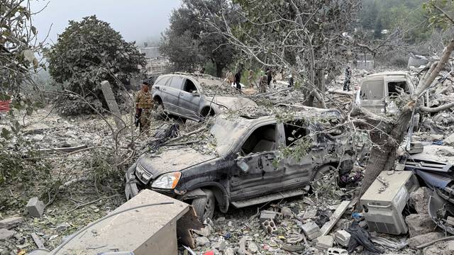 Lebanese army soldier stands at a site damaged by an Israeli air strike in Aitou