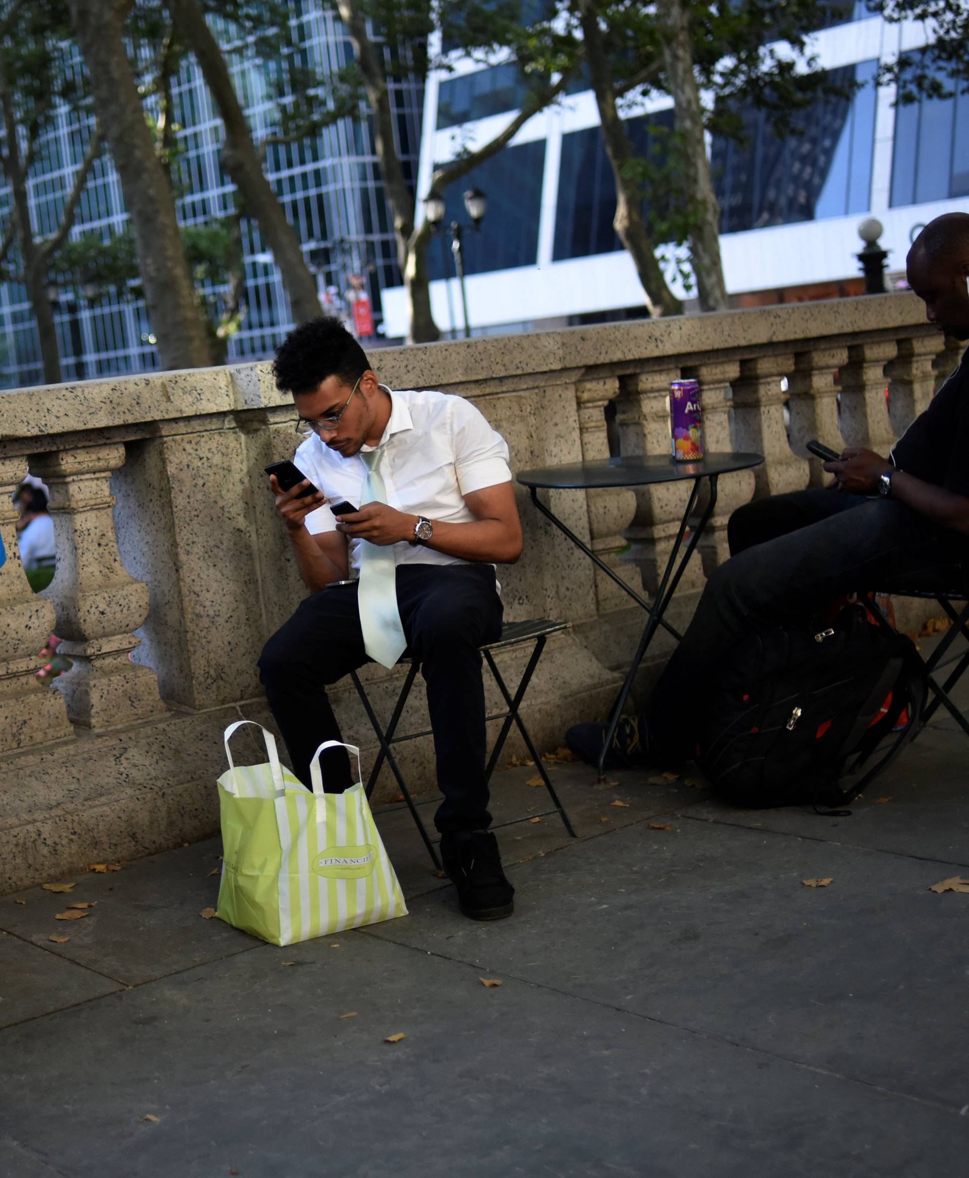 David Melendez uses three phones as he plays the augmented reality mobile game "Pokemon Go" by Nintendo in New York City