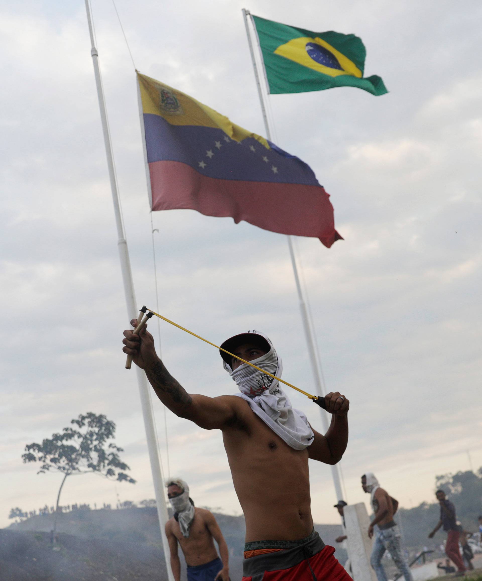 A protester uses a slingshot during clashes with Venezuelan soldiers along the border between Venezuela and Brazil in Pacaraima