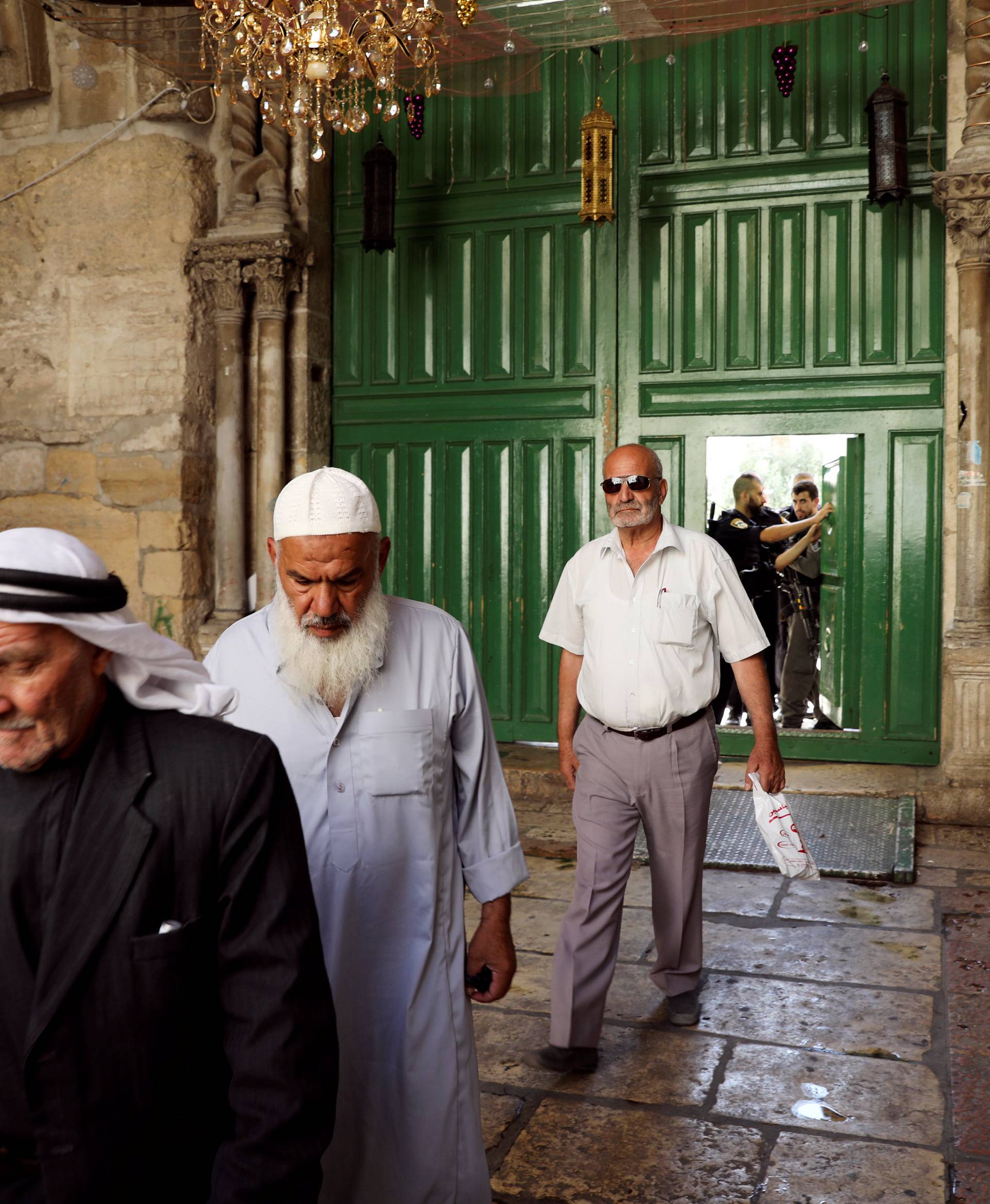 Muslim men walk out from the compound known to Muslims as Noble Sanctuary and to Jews as Temple Mount, in Jerusalem's Old City