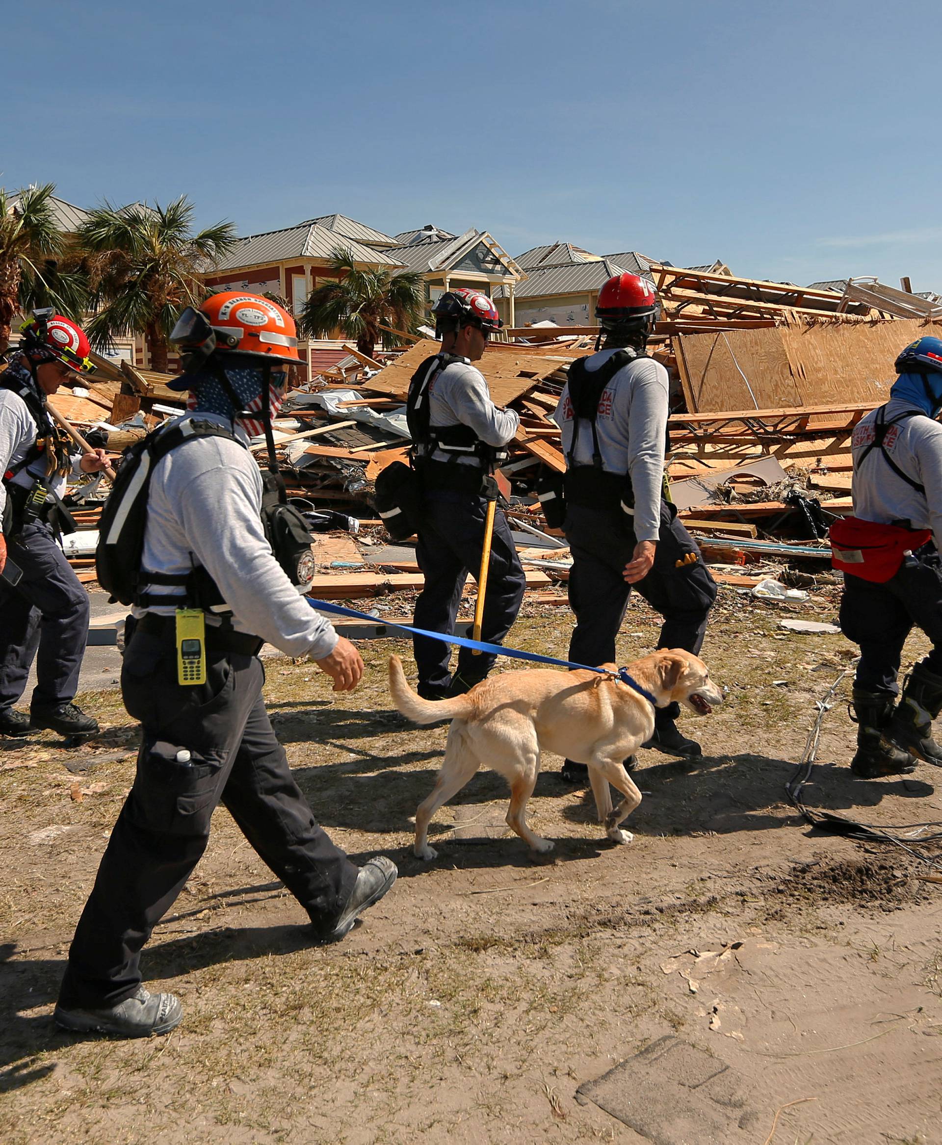 Search and rescue crews walk past damage caused by Hurricane Michael in Mexico Beach