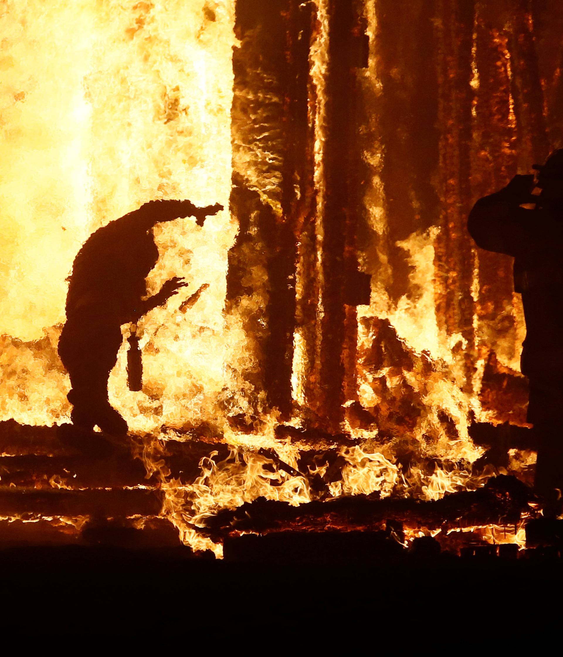 Burning Man participant runs into the flames of the "Man Burn" at the Burning Man arts and music festival in the Black Rock Desert of Nevada