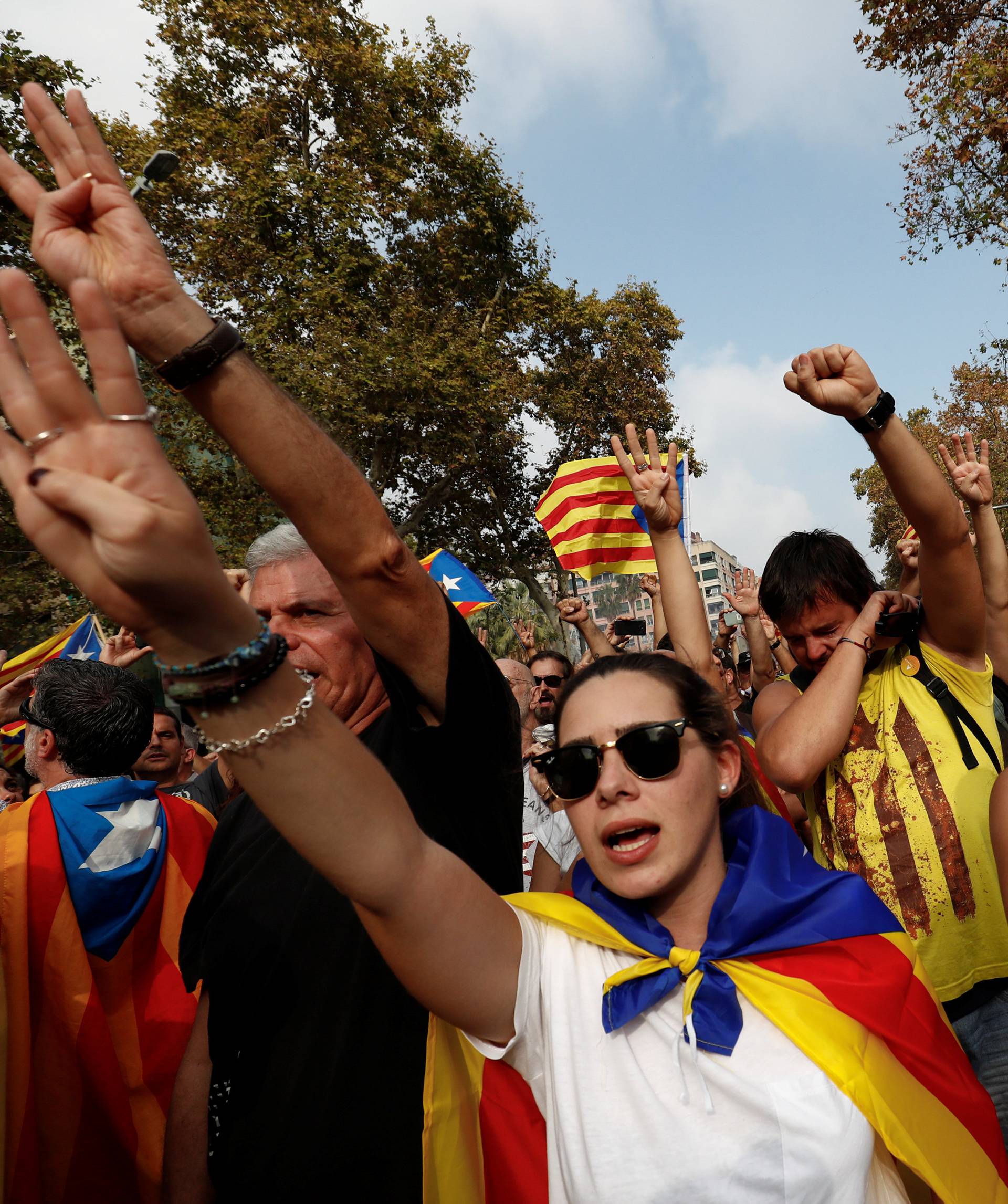 People sign Catalan anthem as they celebrate after the Catalan regional parliament declares the independence from Spain in Barcelona