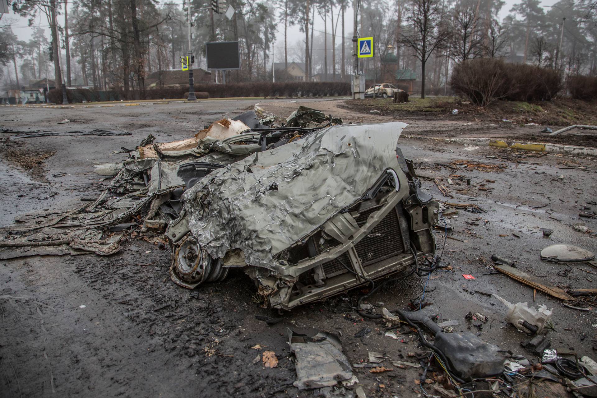 Squashed cars are seen on an empty street in the town of Bucha