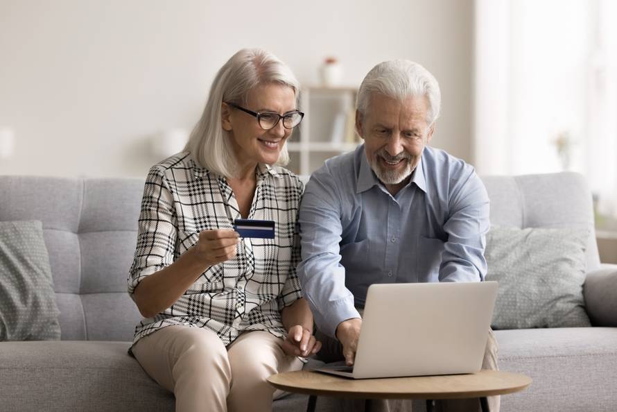 Cheerful,Elderly,Couple,Spend,Time,At,Home,With,Laptop,,Shopping