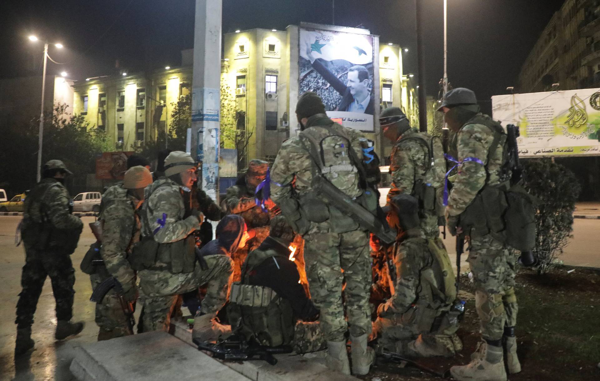 Syrian opposition fighters gather around a fire to keep themselves warm at Saadallah al-Jabiri Square, after rebels opposed to President Bashar al-Assad said they had reached the heart of Aleppo