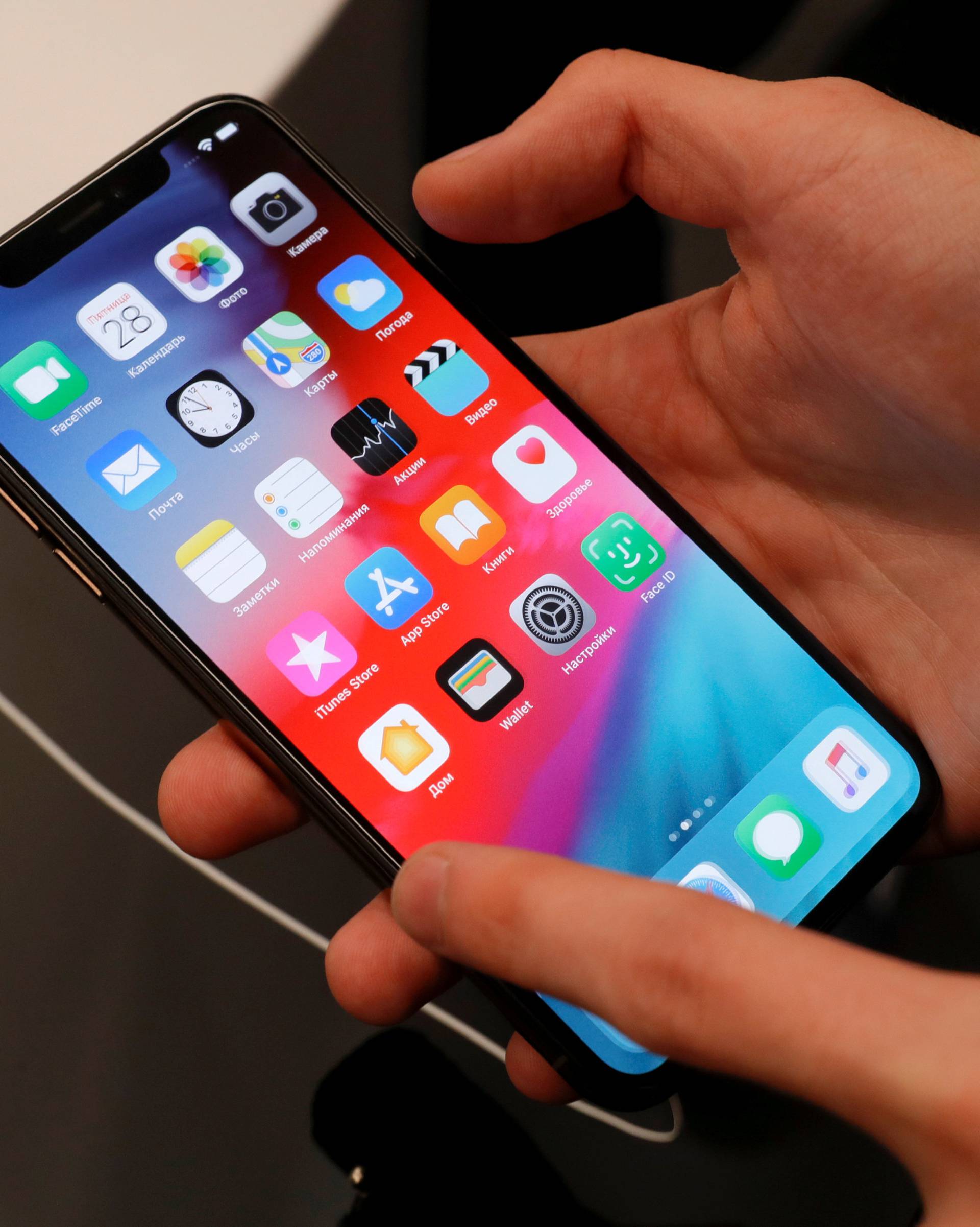 FILE PHOTO: A customer tests a smartphone during the launch of the new iPhone XS and XS Max sales at a shop in Moscow