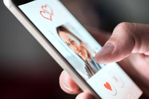 Online dating app in smartphone. Man looking at photo of beautif