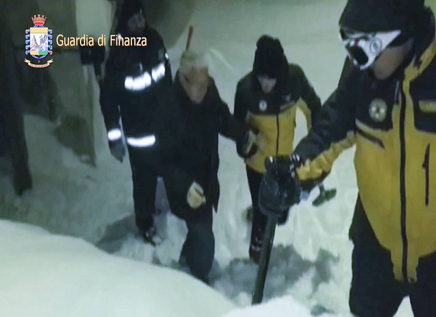 A photo taken from a video shows a survivor, helped by rescuers, coming out from Hotel Rigopiano in Farindola, central Italy, hit by an avalanche