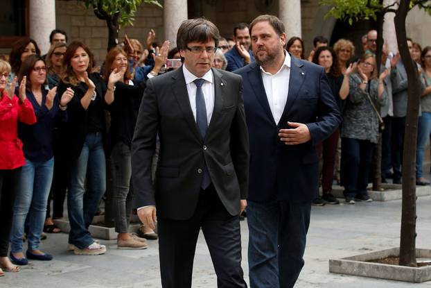 Catalan President Puigdemont and Vice President Junqueras are applauded by employees upon arriving to an extraordinary cabinet meeting in Barcelona