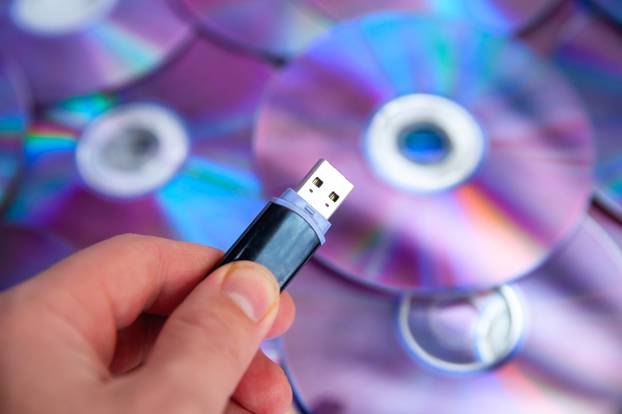 Usb,Flash,Drive,In,The,Hand,On,Background,Dvd,Discs