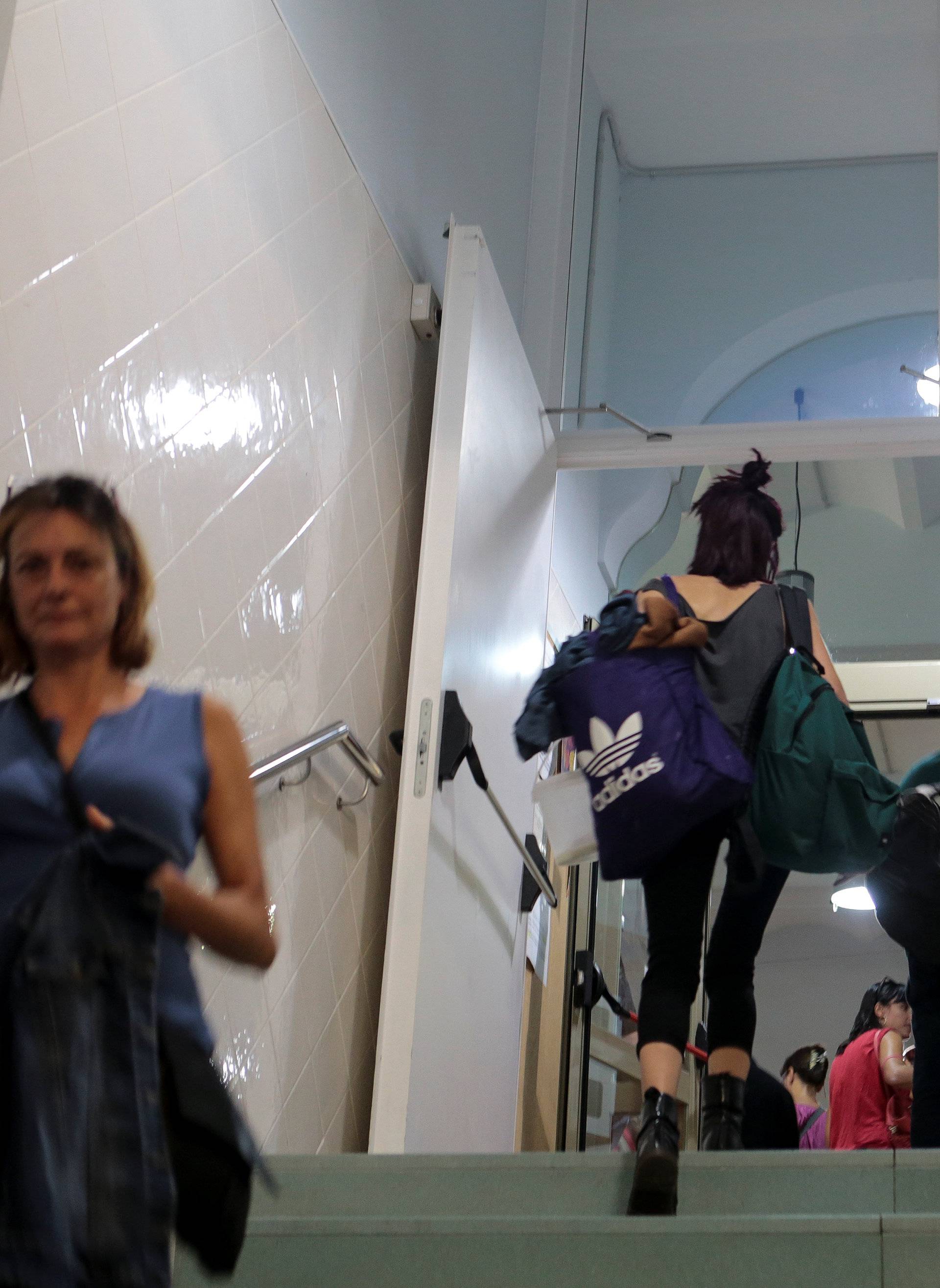 People enter the Miquel Tarradell high school, one of the designated polling stations, after students left for the day to occupy the premises in a bid to permit voting in the banned independence referendum in Barcelona