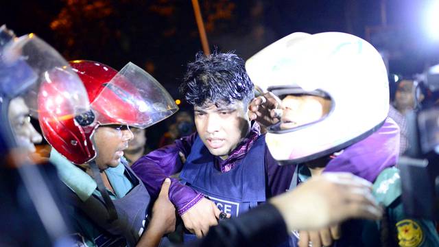 An injured member of the police personnel is carried away by his colleagues after gunmen stormed a restaurant popular with expatriates in the diplomatic quarter of Dhaka