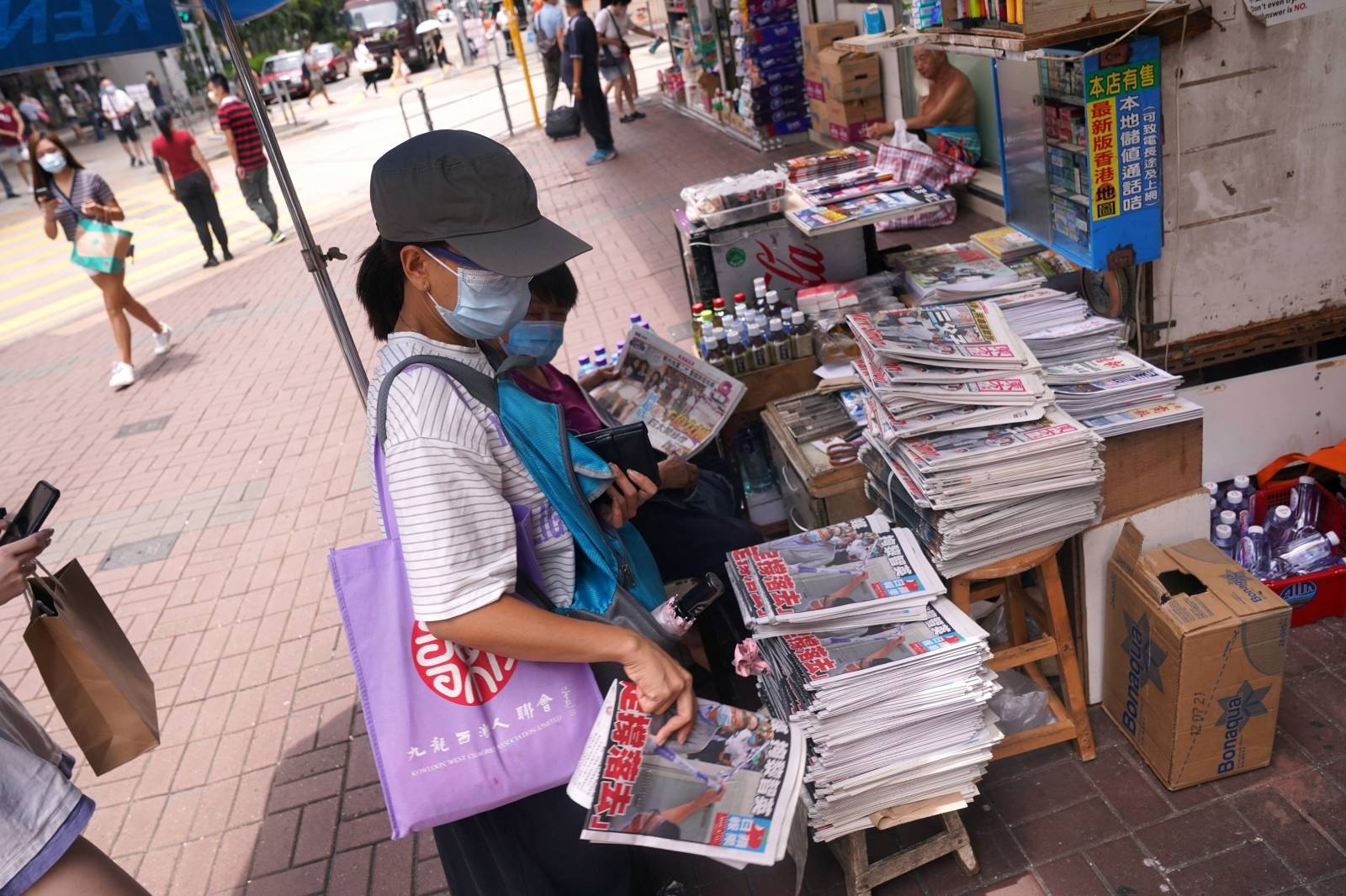 People buy the Apple Daily newspaper at a street stall in Hong Kong