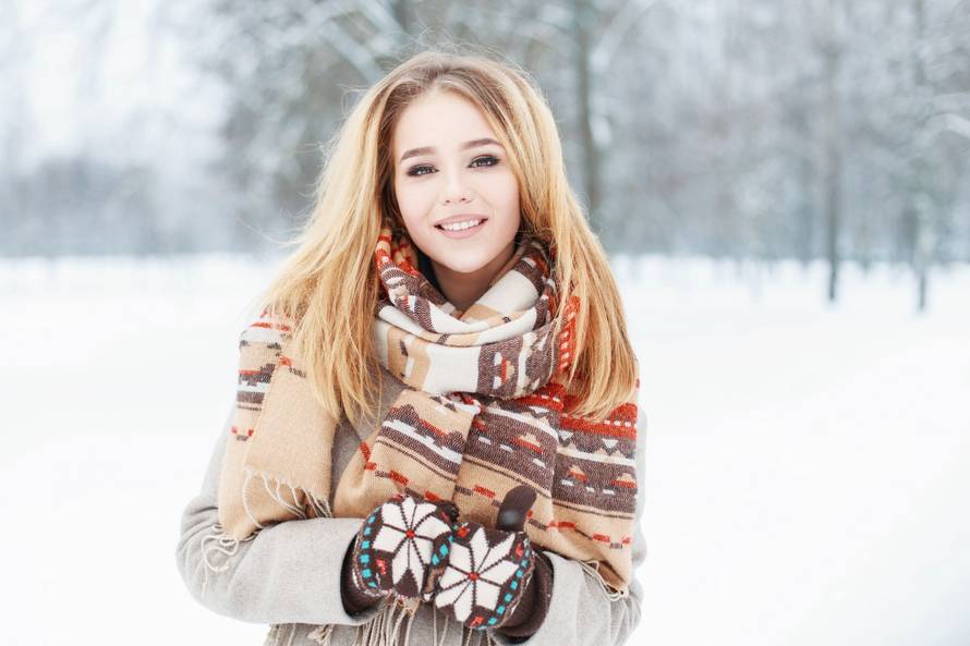 Young beautiful girl with a cute smile in vintage scarf and mitt