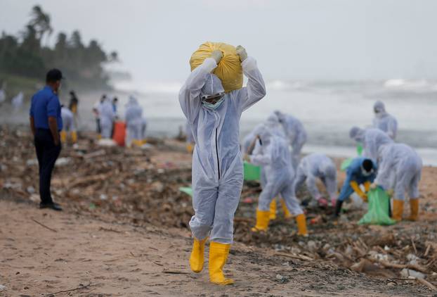 Sri Lankan navy members remove debris washed off to a beach from the MV X-Press Pearl container ship