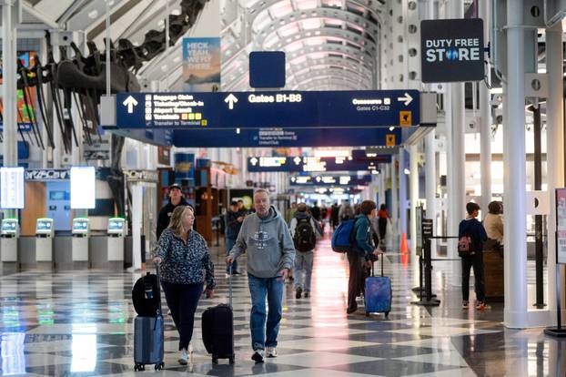 FILE PHOTO: Travelers walk through Chicago O'Hare International Airport