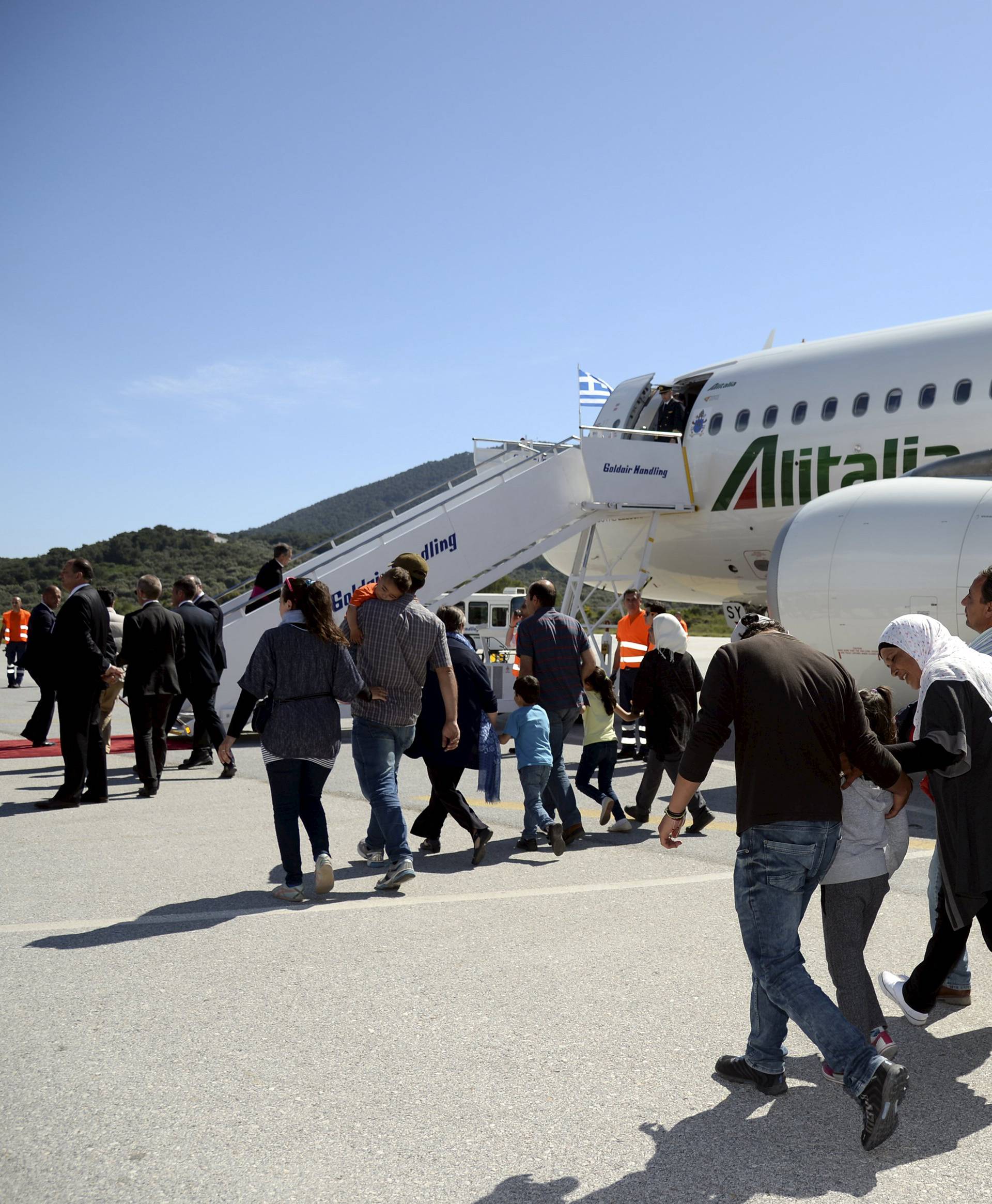 A group of Syrian refugees arrive to board a plane with Pope Francis at the airport of Mytilene, in the Greek island of Lesbos