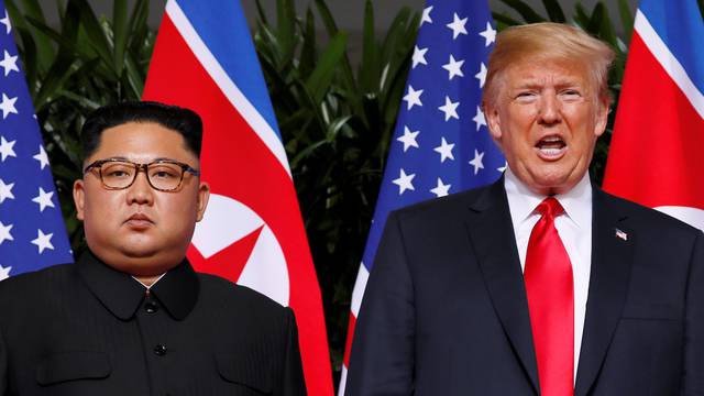 U.S. President Donald Trump and North Korean leader Kim Jong Un react at the Capella Hotel on Sentosa island in Singapore