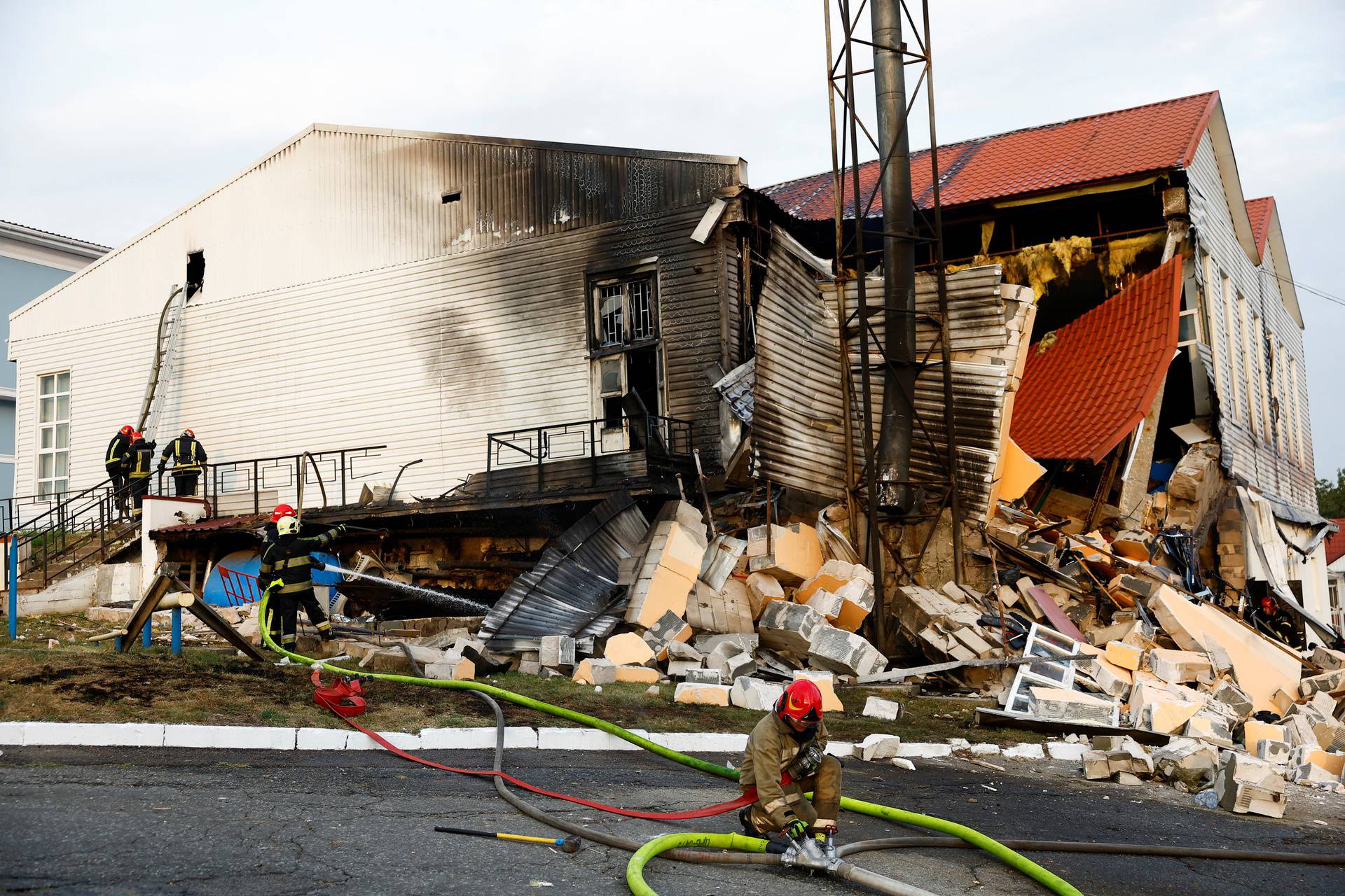 Firefighters work at a site of a sports complex of a university damaged during a Russian missile strike in Kyiv