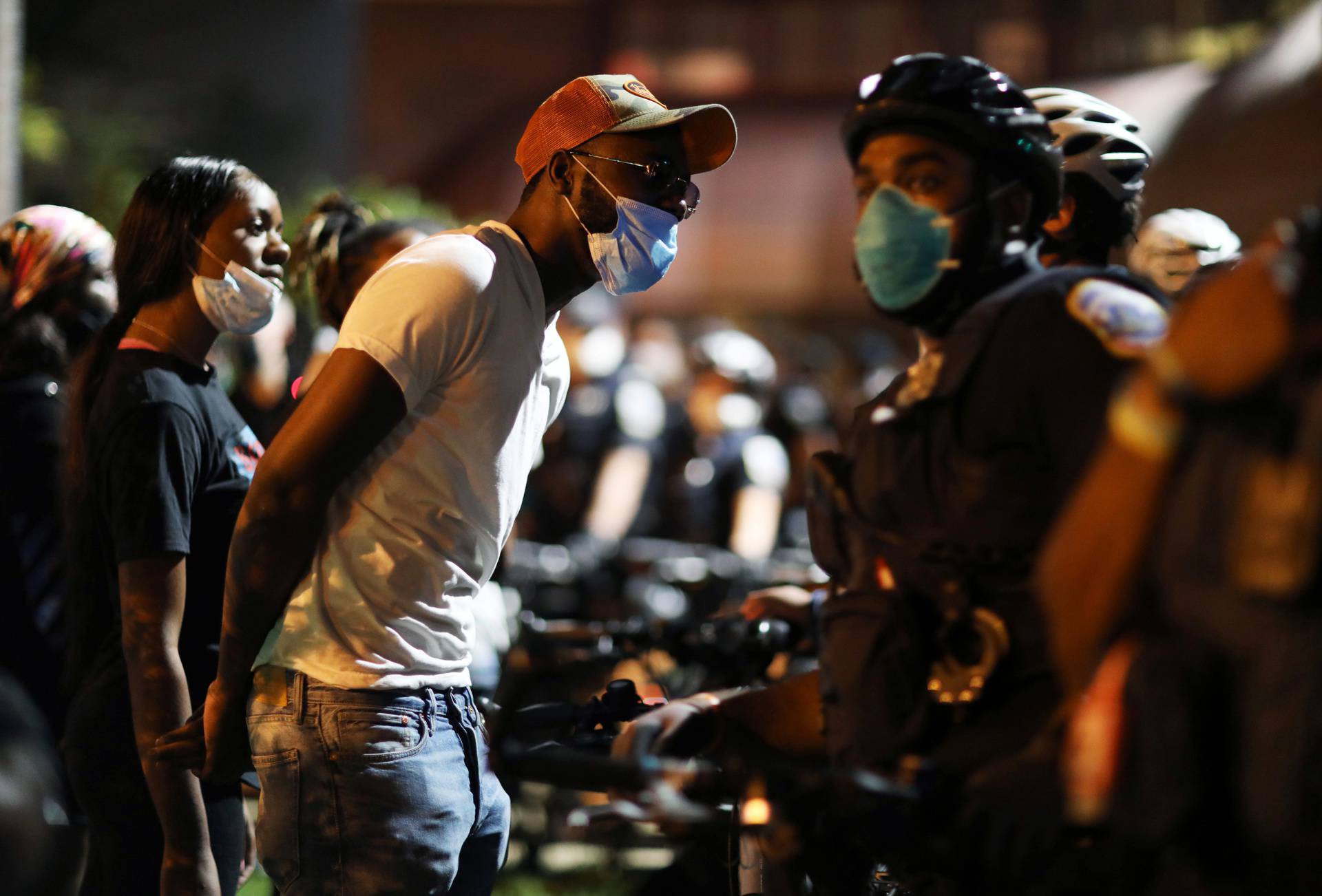 Protesters confront police officers outside of the 7th precinct to express their anger after Washington Metropolitan Police Department shot and killed a young black man in South East DC