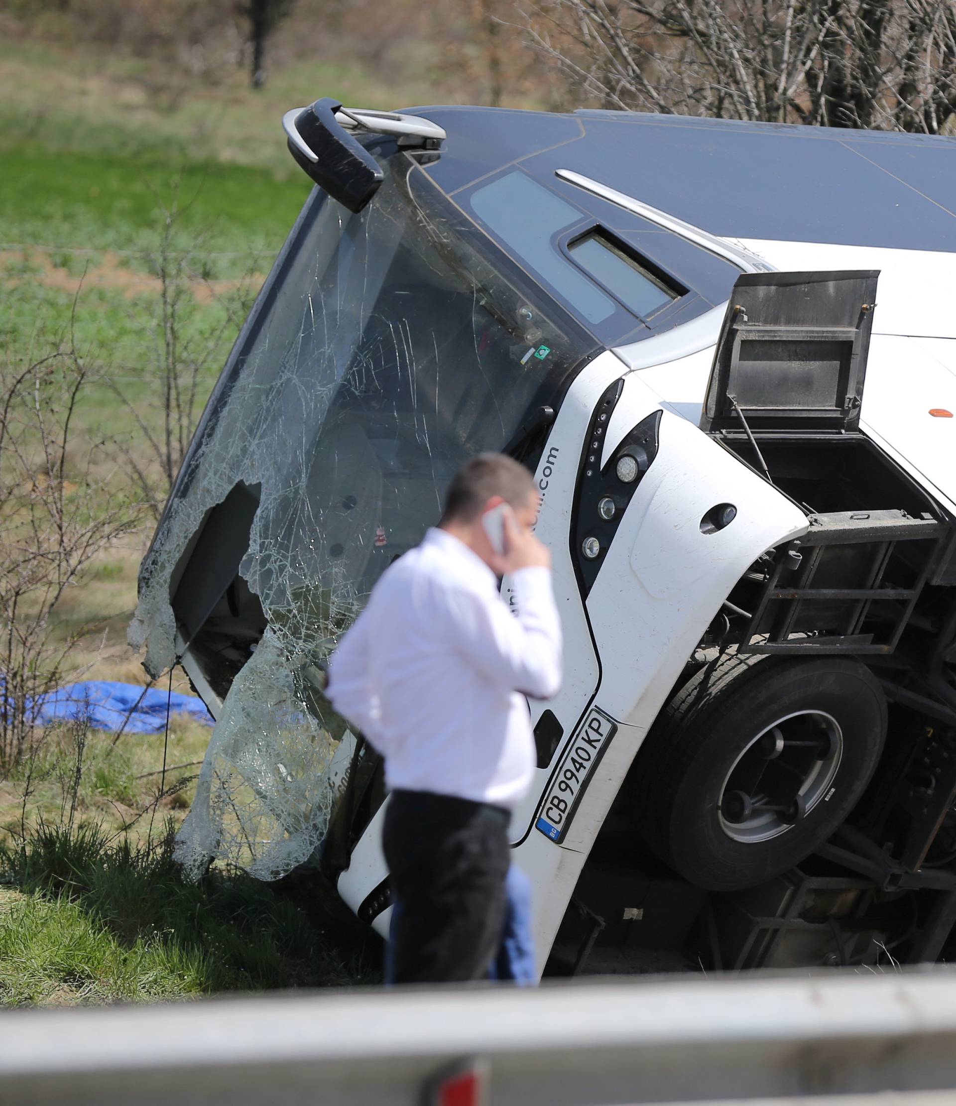 A man walks beside a crashed bus on a highway near capital Sofia