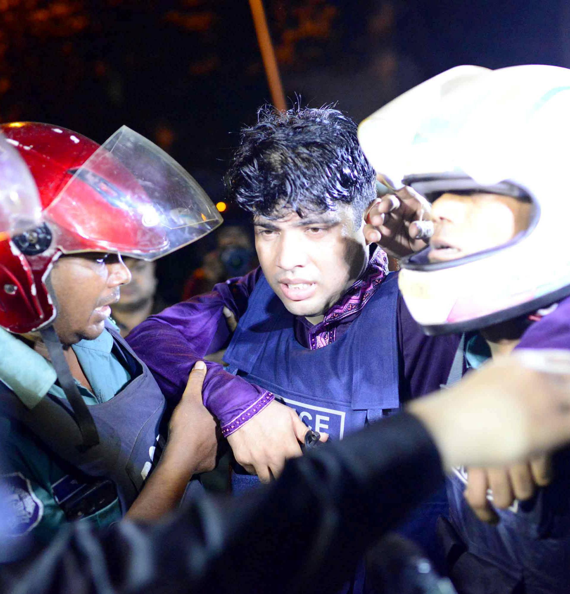 An injured member of the police personnel is carried away by his colleagues after gunmen stormed a restaurant popular with expatriates in the diplomatic quarter of Dhaka