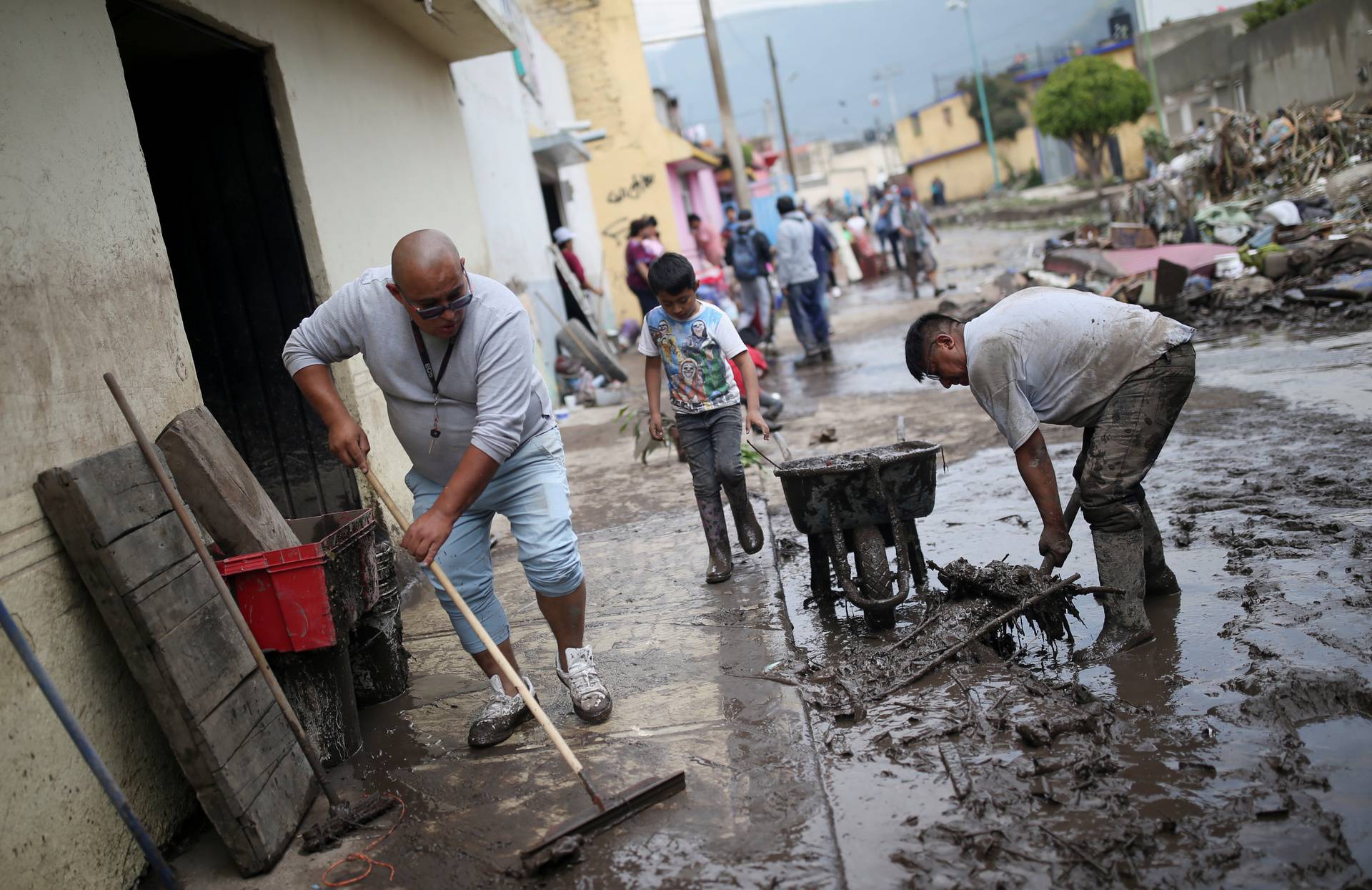 People clean up debris of the damage caused by heavy rainfall in the municipality of Ecatepec