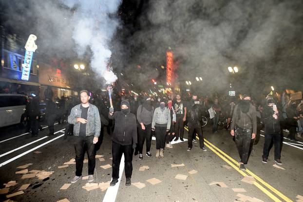 A protester shoots fireworks at police officers during rioting in Oakland, California, U.S. following the election of Donald Trump as President of the United States