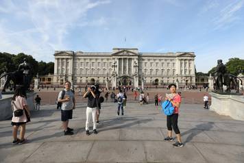 Tourists are seen outside Buckingham Palace in London