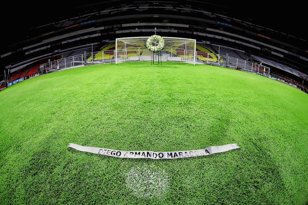 A sign is seen in front of the picture of Maradona and a wreath where Maradona scored a goal in the 1986 World Cup, in Mexico City